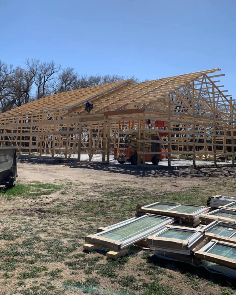 Post-frame shell: trusses, purlins, and window package on site